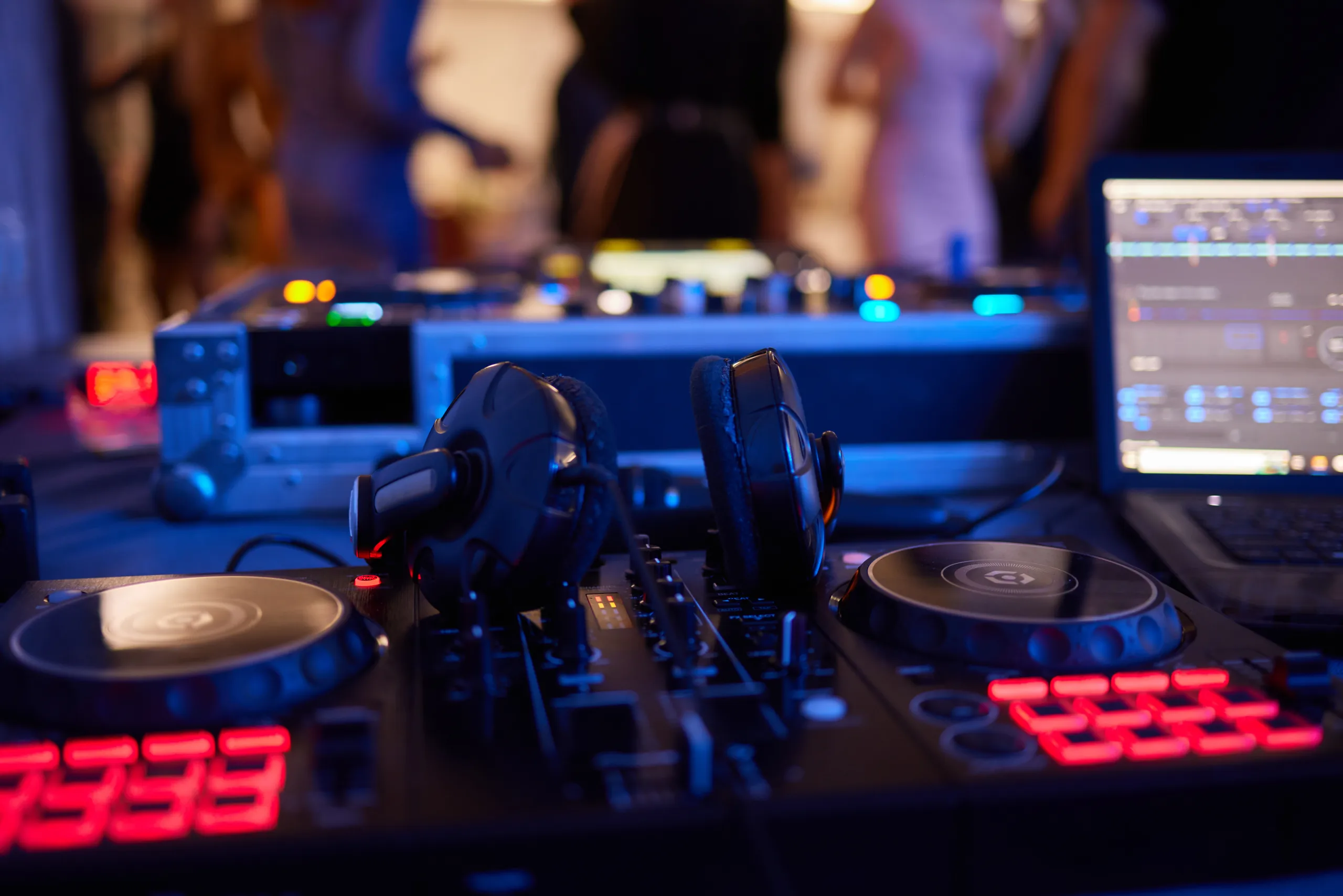 Für volle Tanzflächen und beste Stimmung – DJ Andy Beins DJ-Pult mit Kopfhörer und DJ-Controller vor gefüllter Tanzfläche auf einer Hochzeit